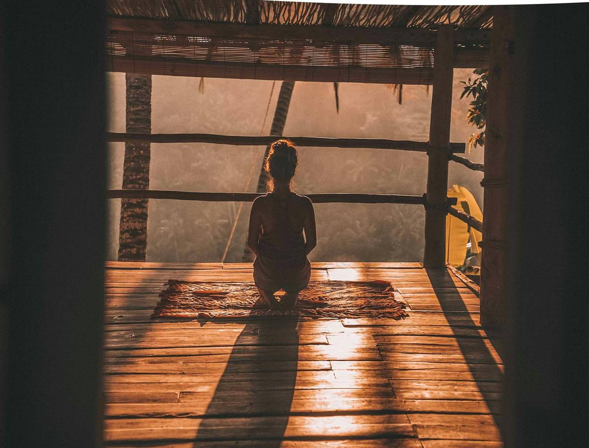 mindfulness guide showing a person sitting comfortably with eyes closed, hands resting on knees, practicing beginner meditation