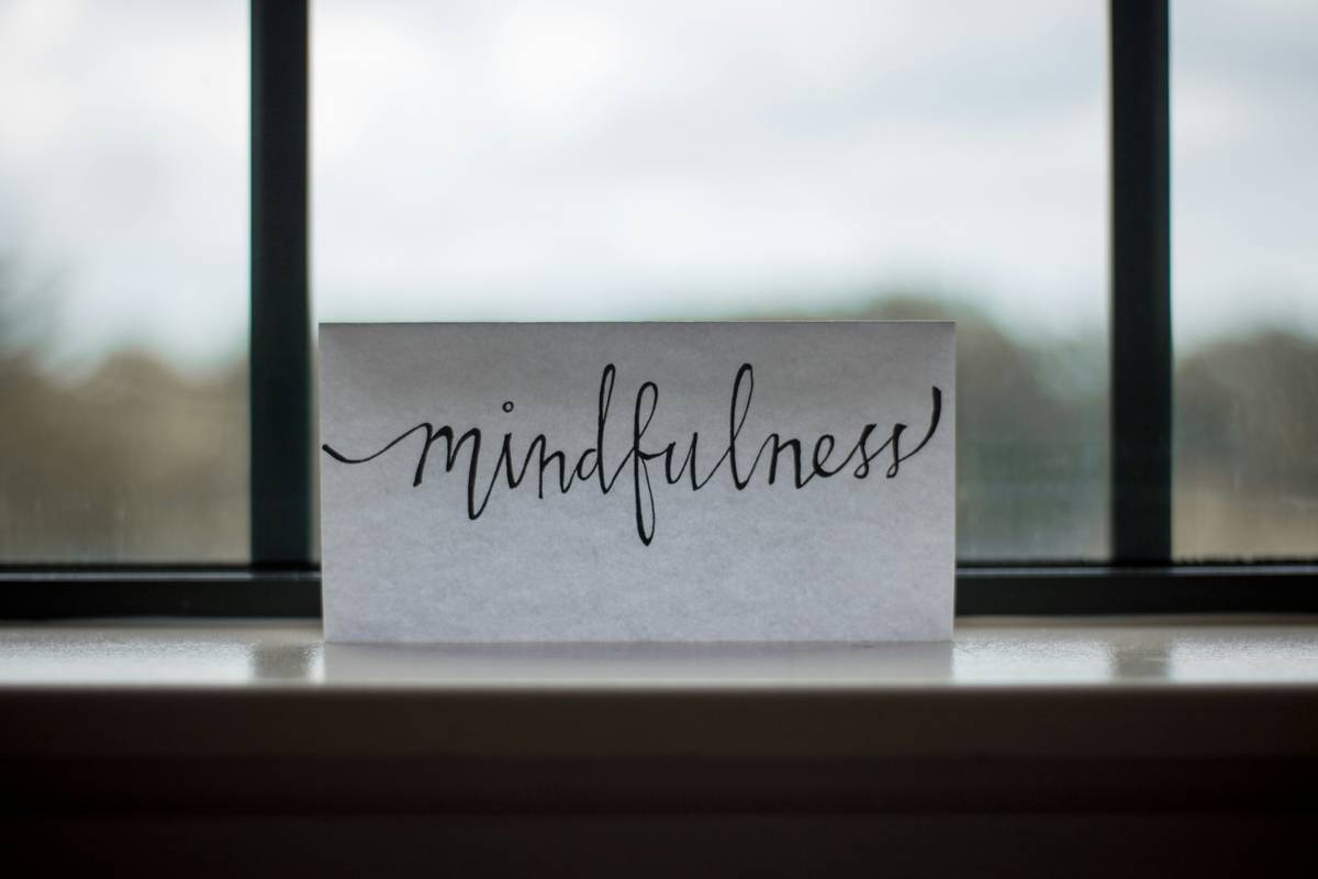 A person sitting comfortably on a couch practicing mindfulness basics with eyes closed and hands resting gently on their lap